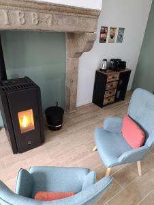 a living room with two chairs and a fireplace at Escapade bien-être avec Sauna et Balnéo - ChezBross' La Parenthèse in Aboën