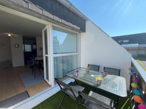 a patio with a table and chairs on a balcony at Appartement les Capucins ROSCOFF in Roscoff