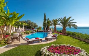 a swimming pool in a yard with chairs and flowers at Villa Palace Clara Apartment 2 island Krk by Vill in Malinska +10 photos