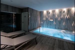 una piscina en una habitación con bañera en Catalonia Magdalenes, en Barcelona