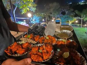 a table topped with plates of food and drinks at Hotel Krushnai Athvan Farm House in Khamshet