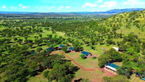 an aerial view of a farm with trees and houses at Maboresho Tented Camp in Serengeti National Park