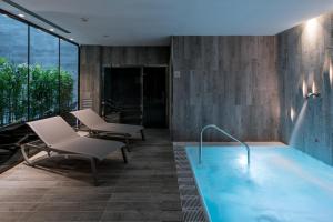 Habitación con piscina con sillas y mesa. en Catalonia Magdalenes, en Barcelona