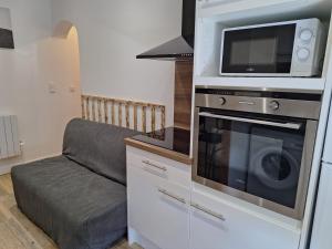 Una cocina con microondas, estufa y un sofá. en Grand T2 lumineux 2 pers Olivet Avenue Loiret, en Olivet 9 fotos más