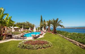 マリンスカにあるVilla Palace Clara Apartment 4 Island of Krk by Viのプールと椅子のある芝生のある庭園 +11枚の写真