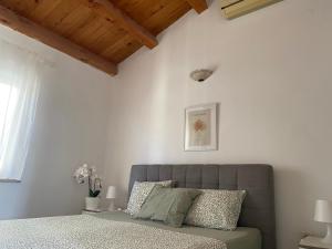 a bedroom with a bed in a room with white walls at Guest House Marta in Rovinj