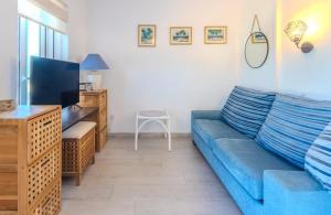 ベグールにある"Terrasse de la Mer 8" Résidence"Sol y Mar" AC-Wifi-BBQ-Piscine-Pkgの青いソファとテレビのあるリビングルーム