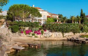 a house sitting next to a body of water at Villa Palace Clara Apartment 5 island Krk by Vill in Malinska