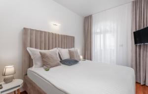 a white bedroom with a large white bed and a window at Villa Palace Clara Apartment 6 island Krk by Villa in Malinska +16 photos