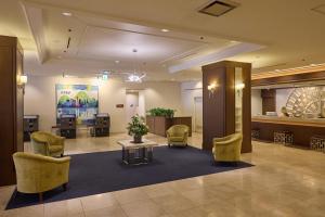 a lobby with a waiting area with chairs and a table at Kobe Sannomiya Tokyu REI Hotel in Kobe