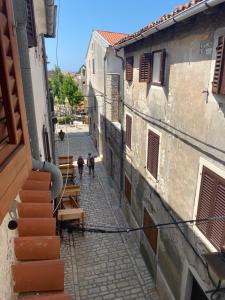 two people walking down a street in an alley at Guest House Marta in Rovinj