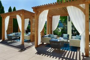 pérgola de madera con sofás y sillas en el patio en The Westin Huntsville, en Huntsville