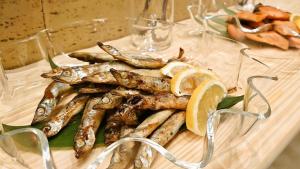 Un plato de pescado sobre una mesa con rodajas de limón. en Green Rich Hotel Matsue Ekimae, en Matsue