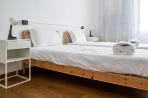 a bedroom with two beds with white sheets and a window at Welc-ōM Montegrotto Terrace View in Montegrotto Terme