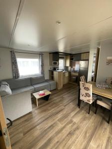 ein Wohnzimmer mit Sofa und Tisch in der Unterkunft Mobilhome in Saint-Jean-de-Monts