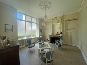 un soggiorno con sedie, tavolo e specchio di Maison d'hôte L'Esperance chic et calme a Saint-Omer