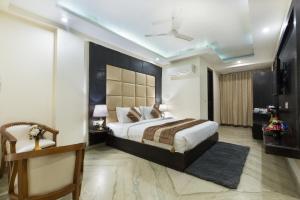 a bedroom with a large bed and a ceiling at VIVVA Premier Delhi Aerocity FREE Airport Pick Up in New Delhi