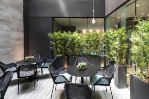 a restaurant with tables and chairs and plants at Catalonia Magdalenes in Barcelona