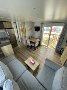 ein Wohnzimmer mit Sofa und Tisch in der Unterkunft Mobilhome in Saint-Jean-de-Monts