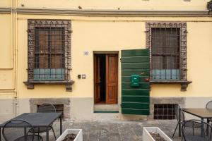 a building with two windows and a door and tables at I Fossi Apartment - Lucca in Lucca