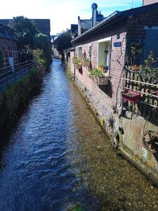 a river with buildings next to at La Durdent - Domaine du Presbytère in La Chapelle-sur-Dun