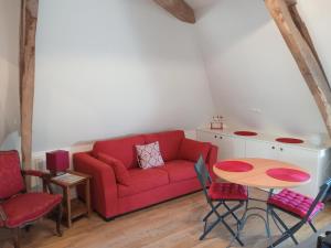 a living room with a red couch and a table at La Durdent - Domaine du Presbytère in La Chapelle-sur-Dun +18 photos