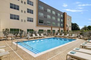 a pool at a hotel with lounge chairs and a building at Element Charleston Airport in Charleston