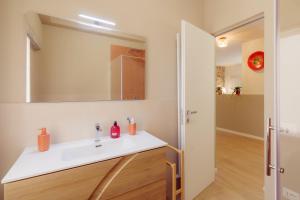 a bathroom with a white sink and a mirror at Winding Village Suite in Trevi +24 photos