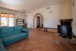 a living room with a blue couch and a television at Villa nel centro Salento - Free Wi-Fi in Ruffano