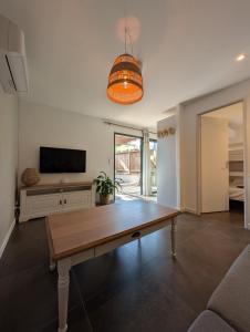 a living room with a table and a flat screen tv at Les Maisons de pêcheur avec Jacuzzi in Sète +49 photos