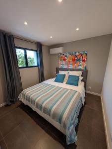 a bedroom with a large bed with blue pillows at Les Maisons de pêcheur avec Jacuzzi in Sète
