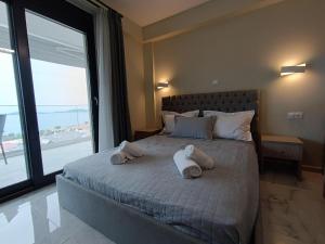 a bedroom with a bed with towels on it at ALTA MARE in Nea Peramos
