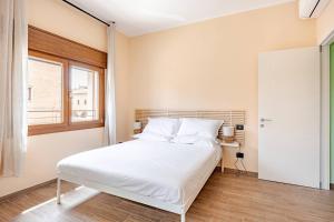 a bedroom with a white bed and a window at Appartamento del Paradosso in Spilamberto