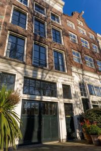 a large brick building with glass windows and doors at Townhouse 't Raap in Amsterdam +24 photos