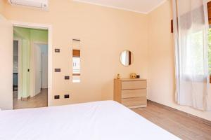 a bedroom with a white bed and a mirror at Appartamento del Paradosso in Spilamberto