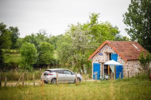 a car parked in front of a small house at Cabane à Mémé in Cosnac