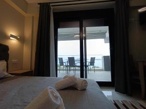 a bedroom with a bed with a view of a patio at ALTA MARE in Nea Peramos