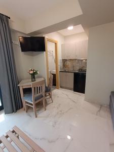 a living room with a table and a kitchen at ALTA MARE in Nea Peramos