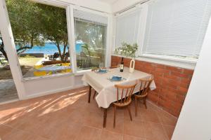 a dining room with a table and two windows at House Ana in Banj