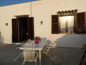 a table and chairs on a patio with a window at La Casa di Aldo e Maria in Marsala
