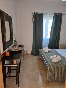 a bedroom with a bed and a dresser and a mirror at Nora Apartment in Almyrida in Chania Town