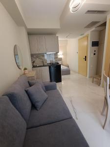 a living room with a blue couch and a kitchen at ALTA MARE in Nea Peramos