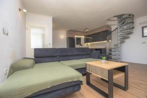 a living room with a blue couch and a table at House Matilda in Primošten