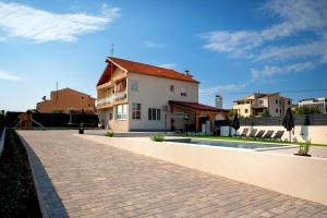 una casa con una pasarela de ladrillo junto a una piscina en House Villa LuNi, en Brodarica