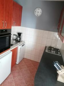 a kitchen with a counter and a clock on the wall at Apartments Katarina 2 in Makarska
