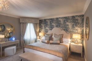 a bedroom with a large bed and a chandelier at Castle Arch Hotel in Trim