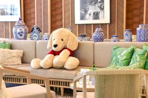 曼谷The Quarter Chaophraya by UHG的坐在沙发上的泰迪熊