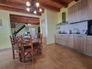 a kitchen and dining room with a wooden table and chairs at Villa Veranda Panoramica by Holiday World in Ravanusa