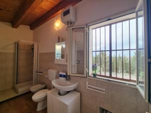 a bathroom with a sink and a toilet and a window at Villa Veranda Panoramica by Holiday World in Ravanusa +32 photos