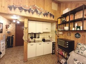 a kitchen with white cabinets and a sink at La casa nel bosco-Val Granara guesthouse in Filettino Graziani